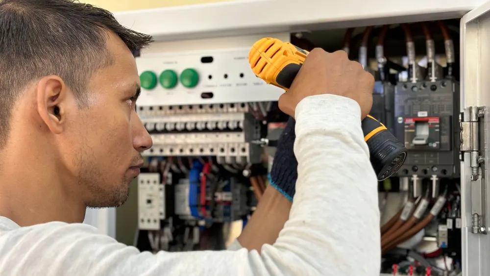 Électricien intervenant sur un tableau électrique
